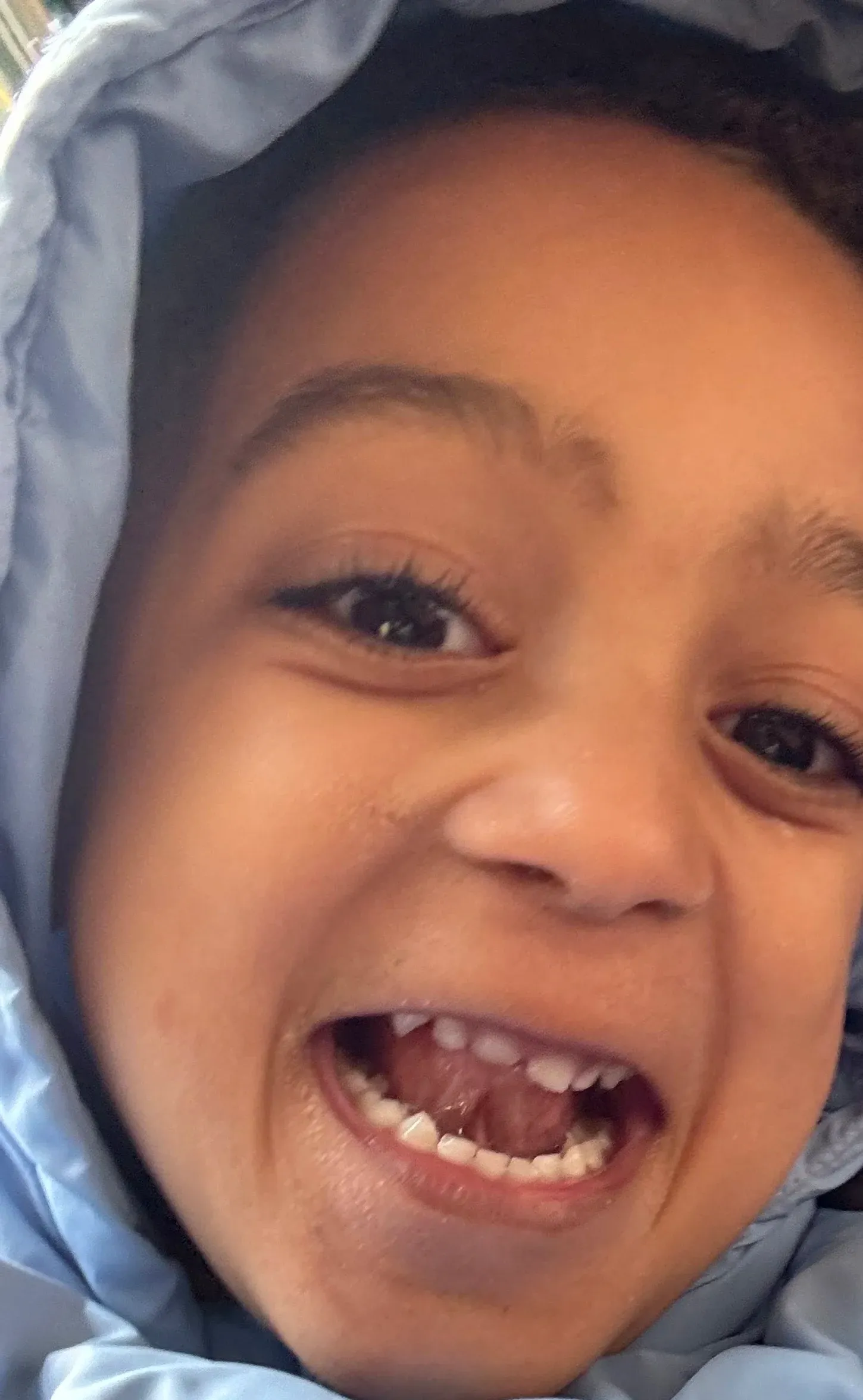 Martí laughing, wrapped in his blue hooded coat